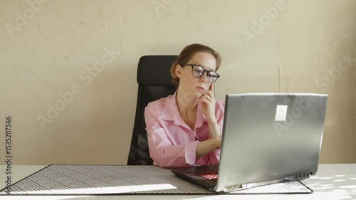 Sad woman at laptop in office, business professional experiencing stress and discomfort, job challenges in a digital workspace.
