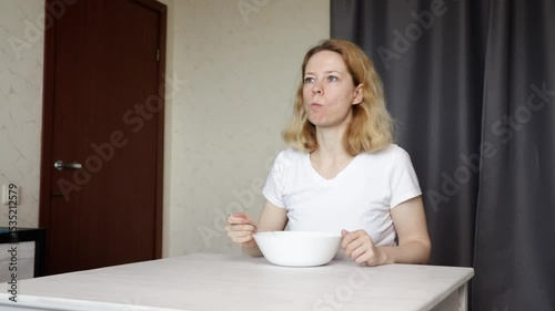 woman Eating Fresh fruit salad, preparing a healthy lunch in the kitchen, focusing on natural nutrition.