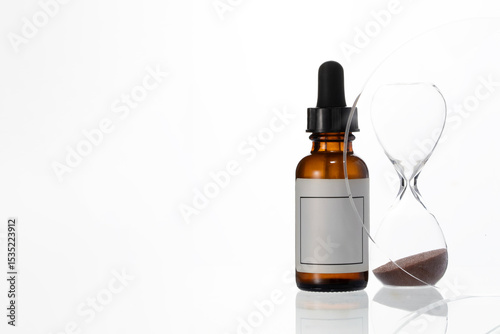 Abstract serum droplet bottle and crystal hourglass. Minimalist anti age beauty concept, sin modern cosmetic photography.