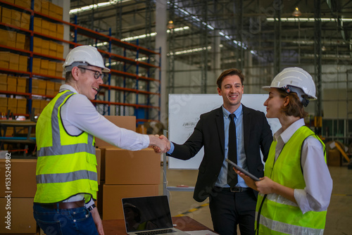 Blue collar workers are working and meeting at warehouse.