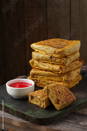 Close up of savory Malaysian murtabak filled with minced beef and chicken served as traditional street food on a plate