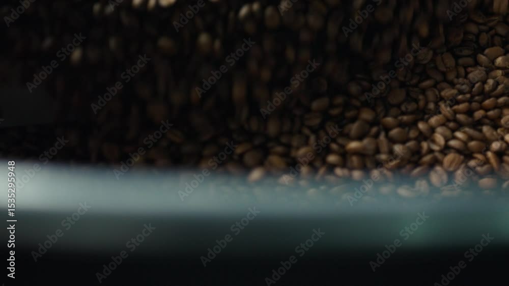 Roasted coffee beans are mixed inside a large industrial roasting machine, ensuring even heat distribution and consistent flavor development