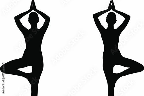 Two Silhouetted Figures in Tree Pose with Hands in Prayer Position.