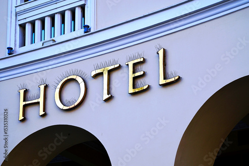 metal spike anti-roosting or bird prevention and repellent strip. bird control. stucco exterior elevation detail. sharp needles. building detail. metal hotel sign. and architecture. pigeon prevention