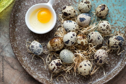 Fresh uncooked quail eggs on a brown plate, horizontal shot, close-up, high angle view