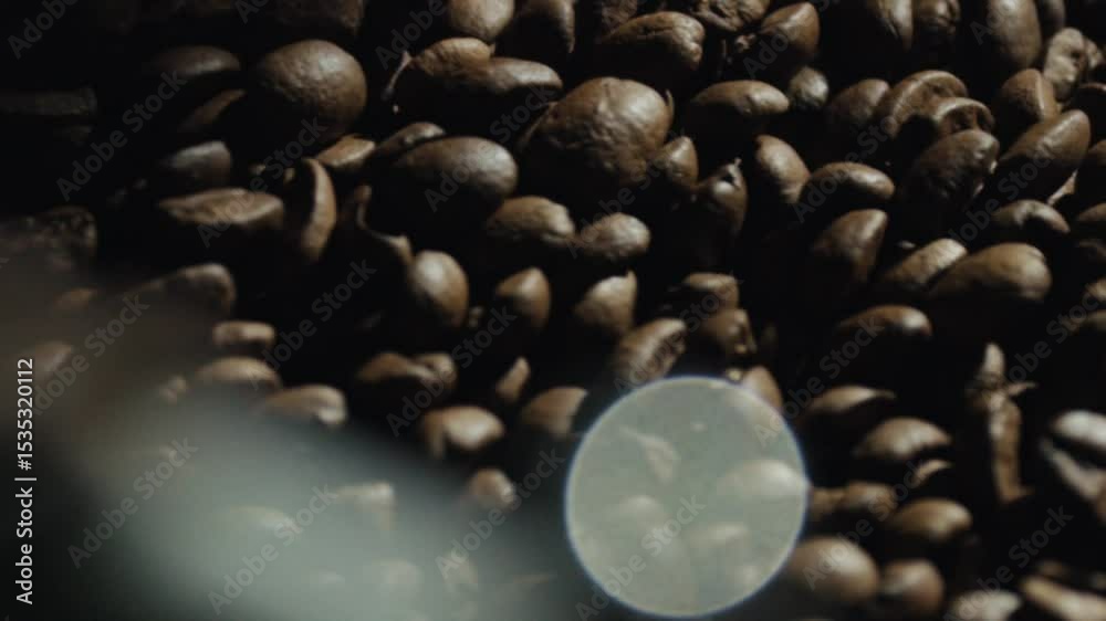 Warm brown coffee beans are rotating inside a professional coffee roaster machine, creating an inviting aroma and preparing for grinding and brewing