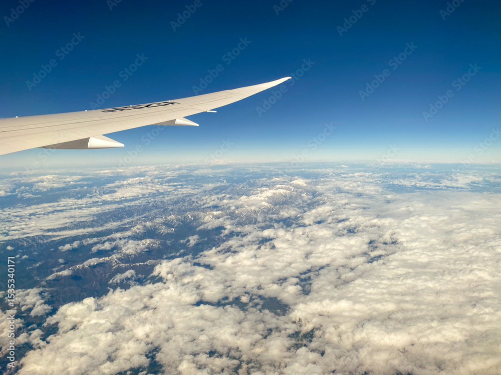 Obraz premium Airplane Wing Over Mountainous Landscape