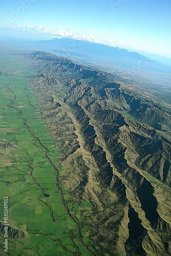 Awe-Inspiring Aerial View of Lush Green Plains and Jagged Mountain Ranges