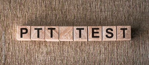 A wooden block arrangement forming the word PTT TEST on a flat surface.