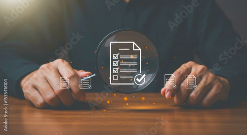 Person holding magnifying glass over checklist icon with documents on a wooden surface view from above