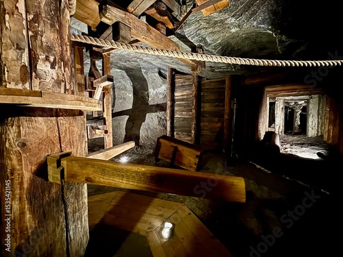 Fotografía A dimly lit wooden tunnel supported by beams inside the Wieliczka Salt Mine, showcasing the engineering and historical mining structures underground in Poland