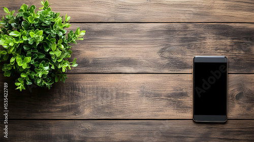 Flat lay of a smartphone and a small green plant on a rustic wooden background.  Perfect for showcasing apps, websites, or technology.