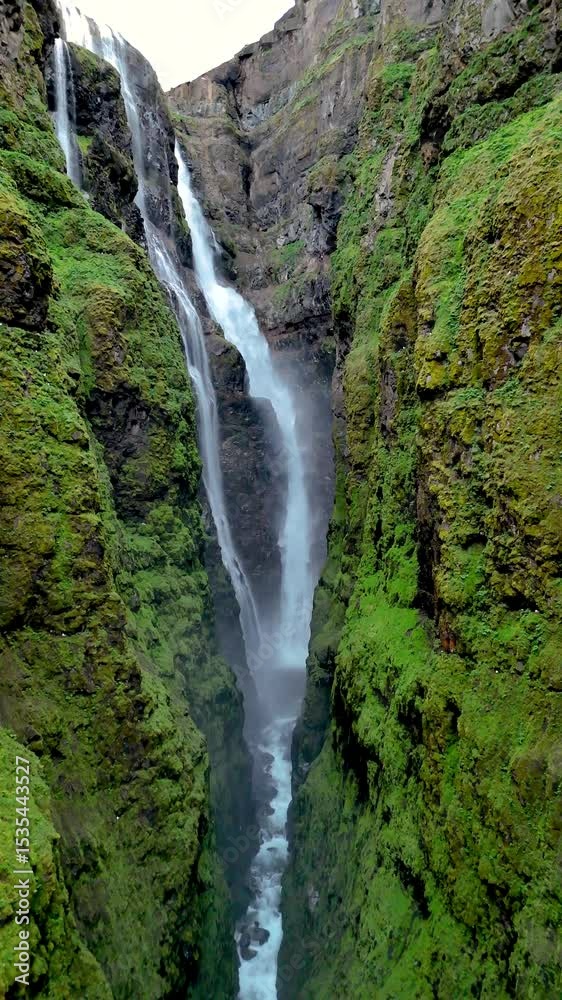 Powerful water cascades down rocky cliffs, surrounded by vibrant moss and vegetation in a breathtaking Icelandic canyon. Glymur waterfall canyon in Iceland Powerful water cascades down rocky cliffs, surrounded by vibrant moss and vegetation in a breathtaking Icelandic canyon. Glymur waterfall canyon in Iceland