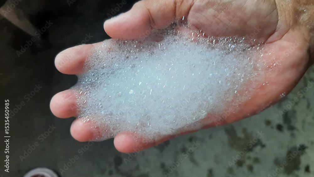 Fototapeta premium soap foam on wrinkled hands that are being cleaned from germs and viruses soap foam on wrinkled hands that are being cleaned from germs and viruses
