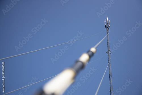Tall Communication Tower Supporting High-Pressure Lines Against Clear Blue Sky