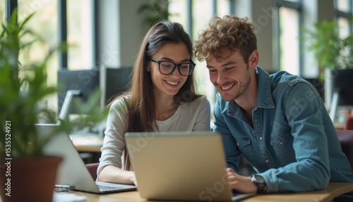 Young couple collaborating on a laptop in a bright workspace