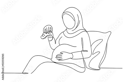 Expecting mother enjoying a tender moment while holding a toddler's shoe in a cozy indoor setting