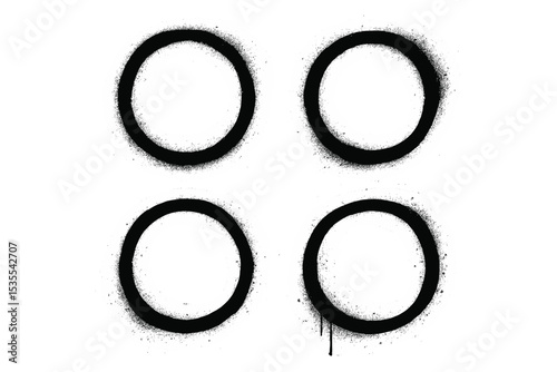 Abstract design featuring four black circles with spray paint texture on a white background