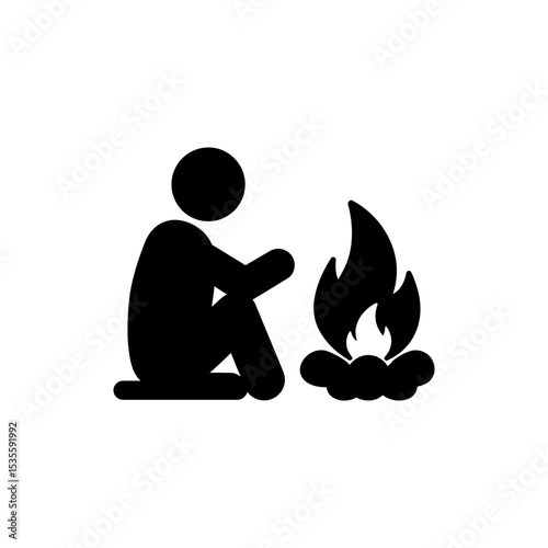 Person sitting relaxed beside campfire outdoors at night