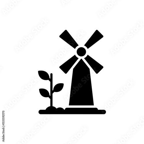 Windmill next to growing green plant sustainable energy concept