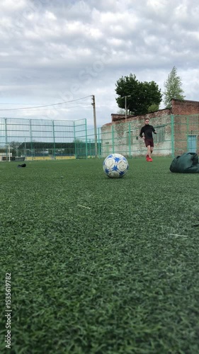 Soccer field with green turf and cloudy sky above