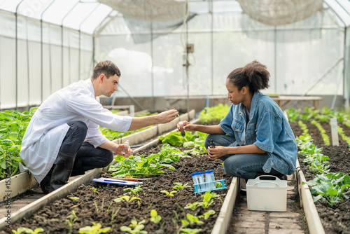 Scientists Collaborating on a Scientific Experiment, Exchanging Samples in a Greenhouse.