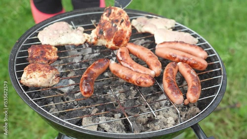 Grilled sausages and meats roasting on a barbecue grill outside. BBQ. Food grilled and smoked over charcoal grills.