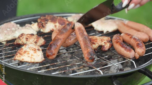 Grilled sausages and meats roasting on a barbecue grill outside. BBQ. Food grilled and smoked over charcoal grills.
