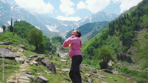 Hiker Indian girl standing in mountains and enjoying view of nature in Manali, Himachal Pradesh, India. Travel and holidays concept.