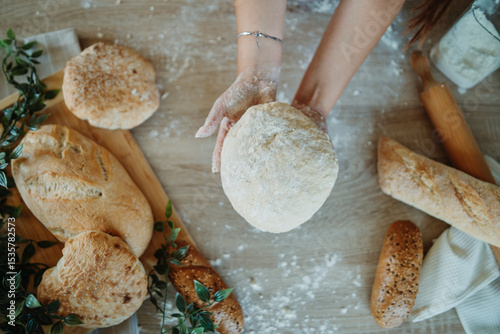 Top view of young caucasian woman's hands kneading a dough 