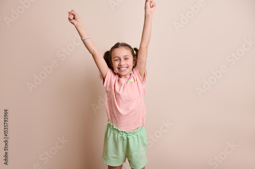Happy Young Girl Celebrating with Arms Raised in Playful Outfit