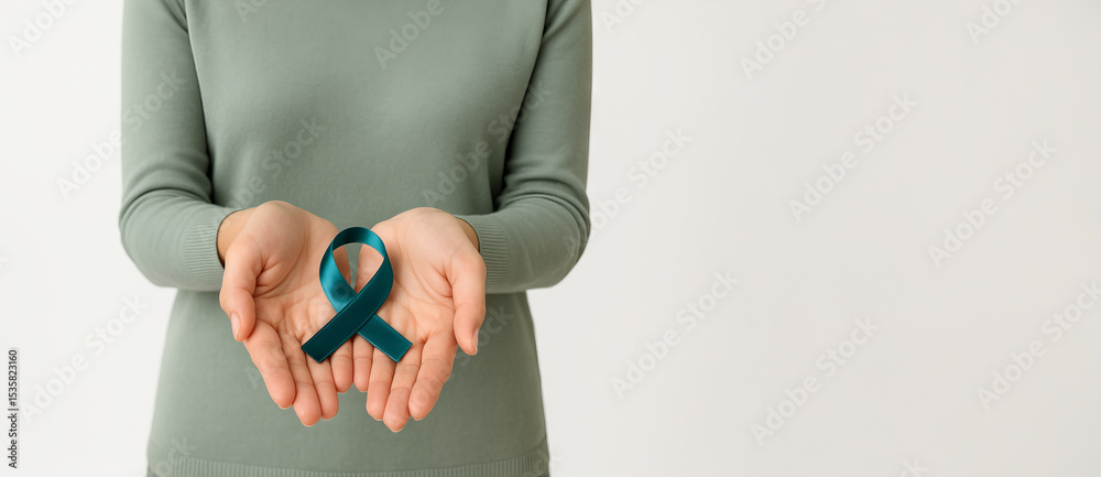 Fototapeta premium Woman holding teal awareness ribbon in hands on white background with copy space. Concept of ovarian cancer support, sexual assault prevention, PCOS awareness, PTSD and mental health, wide banner