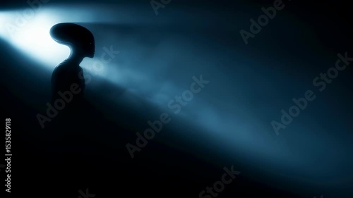 Alien silhouette in mysterious beam of light. UFO concept and extraterrestrial horror with dark blue glow.