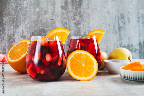 Refreshing summer sangria cocktail with fruits and berries in glasses on the table