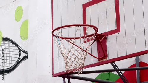 Red basketball hoop with white net in gym