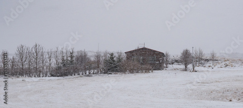 Snow falling on a small wooden house in iceland during winter