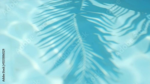 Palm leaf shadow in clear blue water for summer design, tropical backgrounds, vacation themes, relaxation visuals, nature concepts