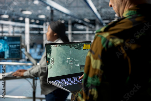 Team of military experts in data center doing mission coordination, operating satellite lock systems. Army units wearing uniform in server farm receiving real time battlefield intel from