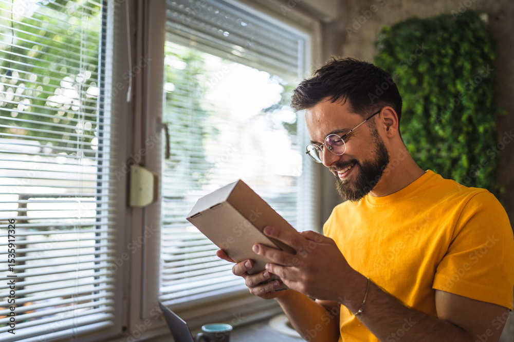 Naklejka premium Delight happy caucasian man with package in the kitchen