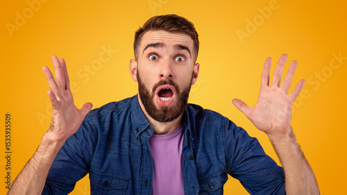 Human emotions and feelings concept. Portrait of shocked Caucasian man with open mouth looking at camera in amazement, making surprised gesture over orange studio background photo