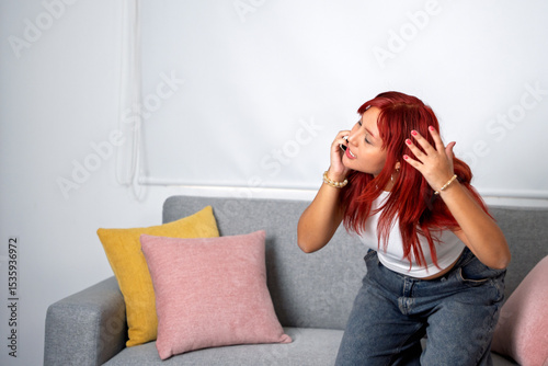 Young woman showing annoyance while talking on mobile phone