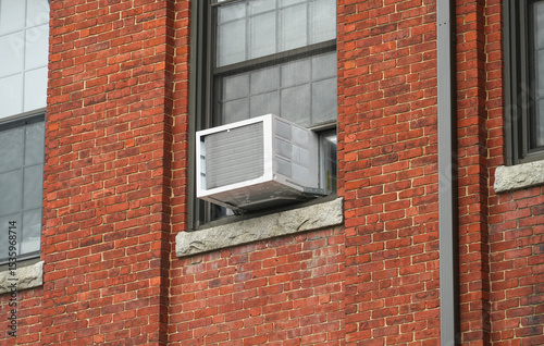 old air conditioner installed on rustic house window