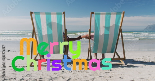 Wallpaper Mural Leaning back couple wearing swimwear holding hands on beach, with striped deck chairs Torontodigital.ca