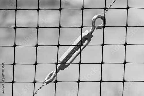 Close up view of steel cable metallic tie joint behind the fence.