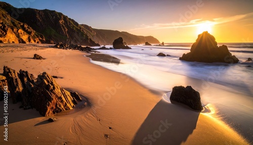 Enchanting coastal panorama: a stunning sunset illuminates the rugged beach
