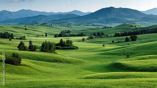 Lush green fields and rolling hills under a clear sky.
