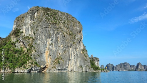 Limestone rock islands in Ha Long bay, Vietnam. The cliff is composed of steep, rugged limestone formations, with vertical striations.