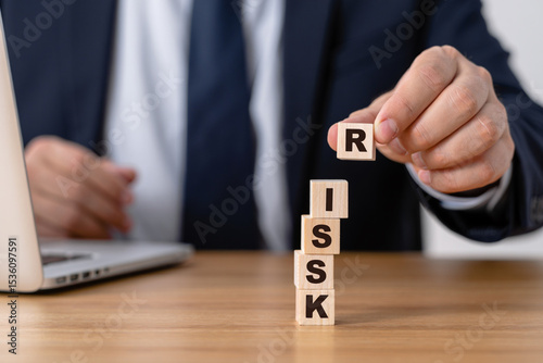 Businessman Building Risk Tower with Wooden Blocks