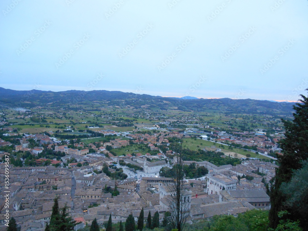 Fototapeta premium イタリア・グッビオの夕暮れ風景｜歴史ある街並みと丘陵に囲まれたウンブリア州の美しい眺め Evening view over historic Gubbio, Italy｜Panoramic landscape of medieval rooftops and Umbrian hills at dusk
