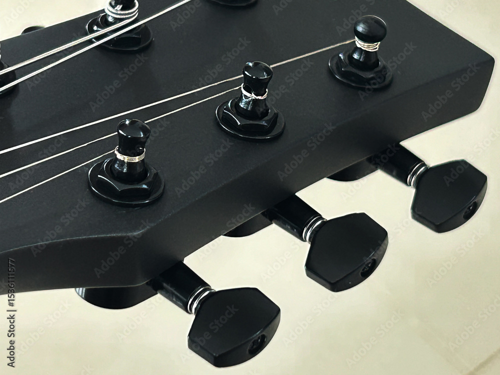 Φωτογραφία A focused shot captures the sleek black headstock of an Enya Nova Go Sonic guitar, highlighting its tuning pegs and the smooth lines of its design